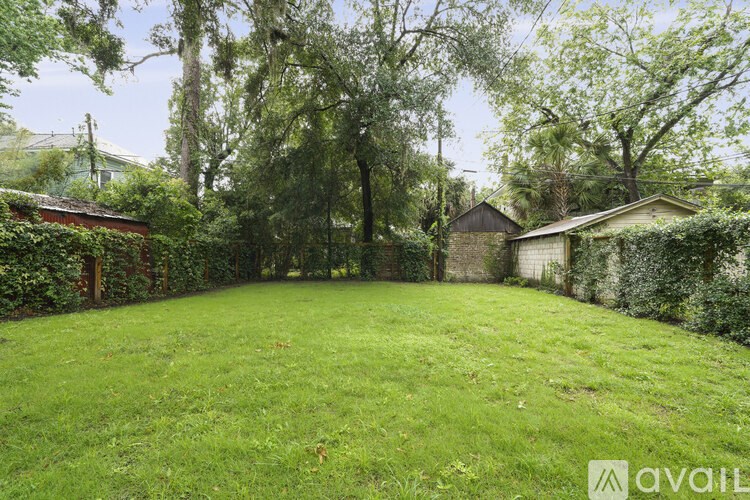 A backyard with a well-maintained lawn and trees.
