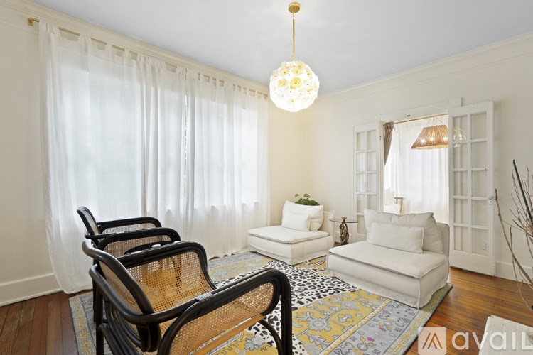 A living room with a black chair and a white sofa.