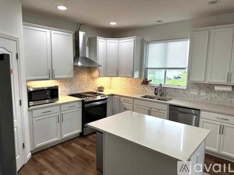 A kitchen with white cabinets and a central island.