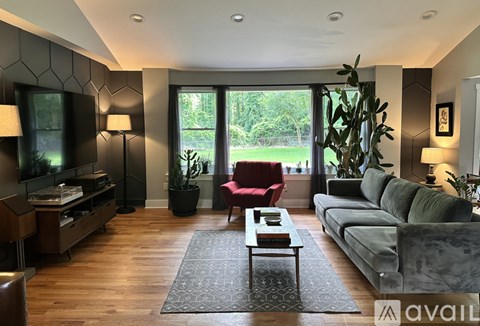 A living room with a red chair and a grey couch.