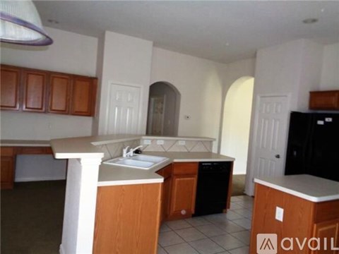 A kitchen with wooden cabinets and a black dishwasher.
