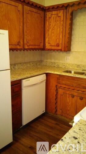 A kitchen with wooden cabinets and a white dishwasher.