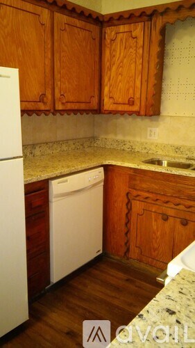 A kitchen with wooden cabinets and a white dishwasher.