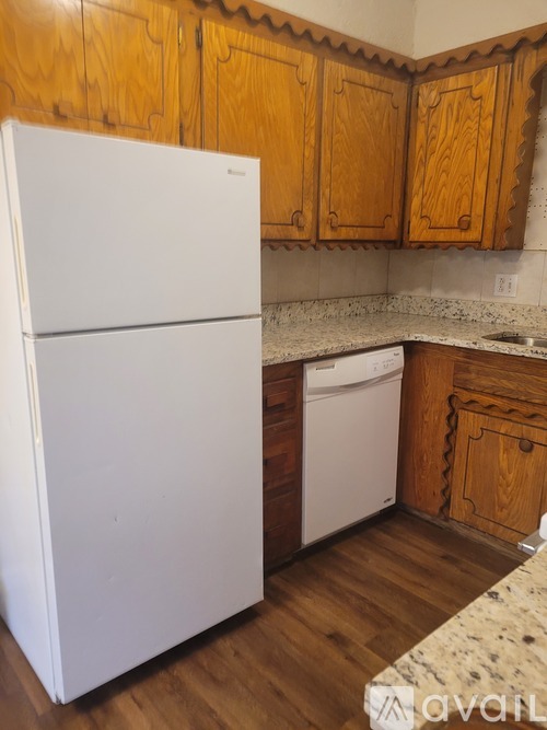 A white fridge in a kitchen with wooden cabinets.