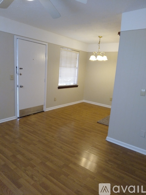 A room with wooden flooring and a white door.