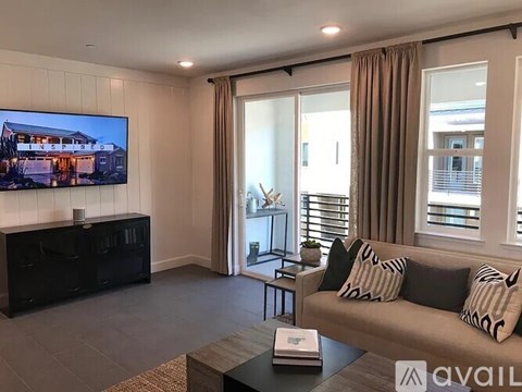 A living room with a couch, a coffee table, and a television displaying an image of a house.