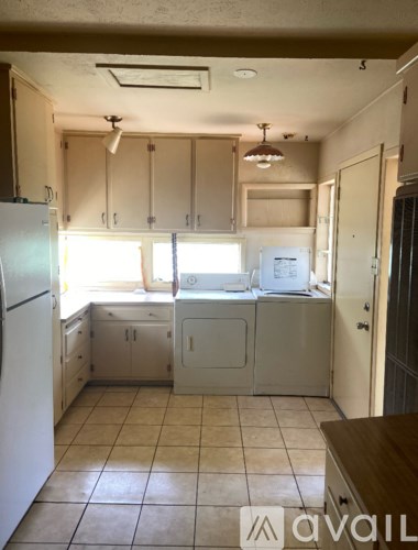 A kitchen with white appliances and cabinets.