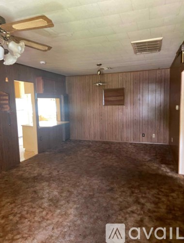 A room with wooden walls and a ceiling fan.