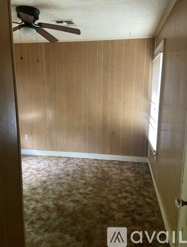 A room with wooden walls and a ceiling fan.