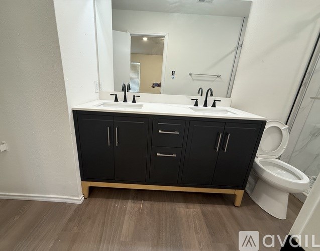 A bathroom with a white toilet and a black cabinet.