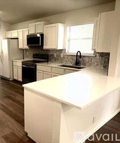 A kitchen with white cabinets and a white island.