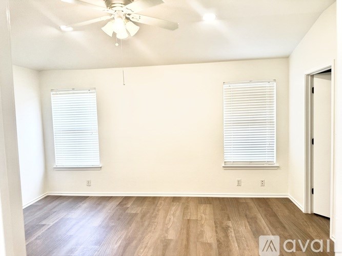 A room with wooden floors and a ceiling fan.