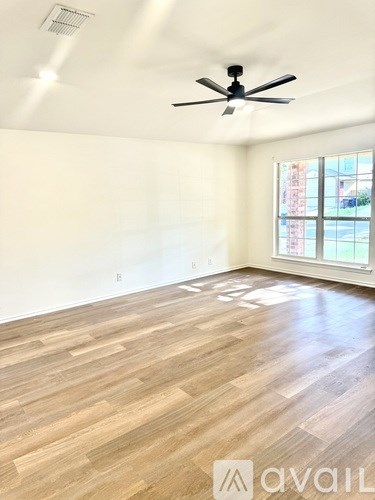 A room with wooden flooring and a ceiling fan.