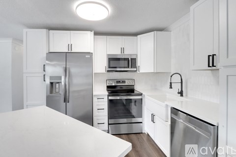 A kitchen with white cabinets and stainless steel appliances.