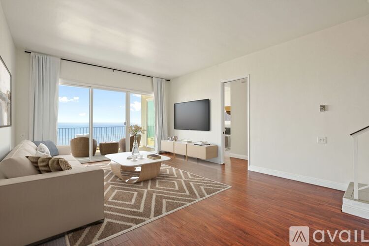 A living room with a couch, a coffee table, and a television.
