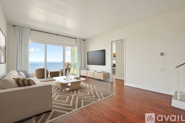 A living room with a couch, a coffee table, and a television.