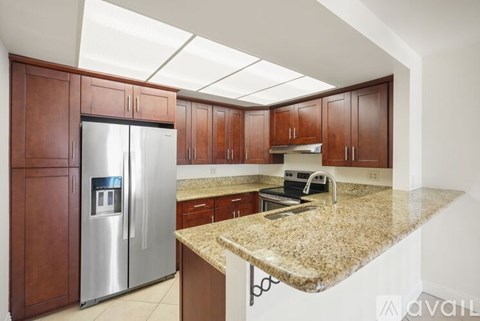 A kitchen with brown cabinets and a granite countertop.