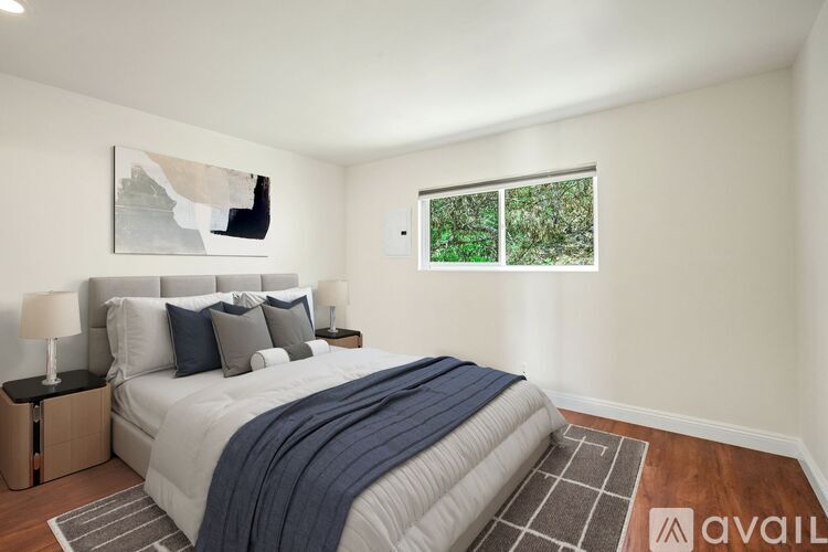 A bedroom with a large bed and a painting on the wall.
