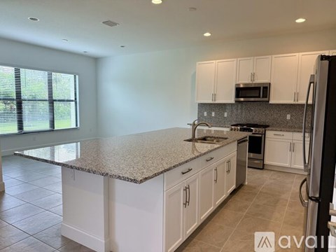 A kitchen with granite countertops and white cabinets.