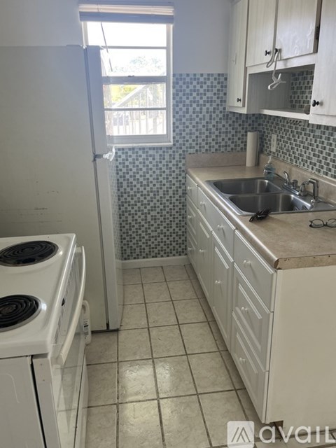 A kitchen with a white stove and white cabinets.