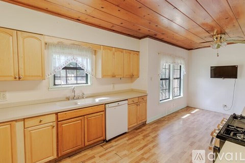 A kitchen with wooden cabinets and a white dishwasher.