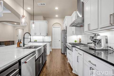 A modern kitchen with white cabinets and stainless steel appliances.