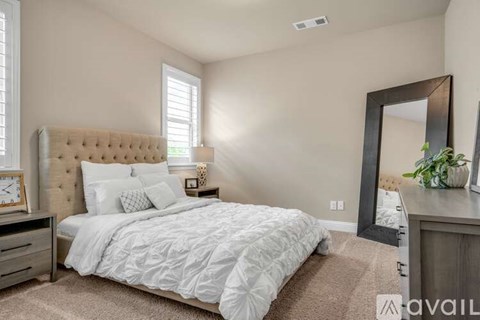 A bedroom with a large bed and a mirror on the wall.