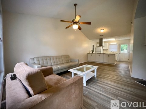 A living room with a brown couch and a white coffee table.