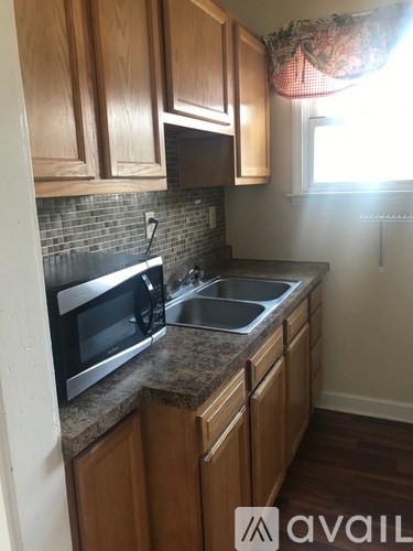 A kitchen with wooden cabinets and a granite countertop.