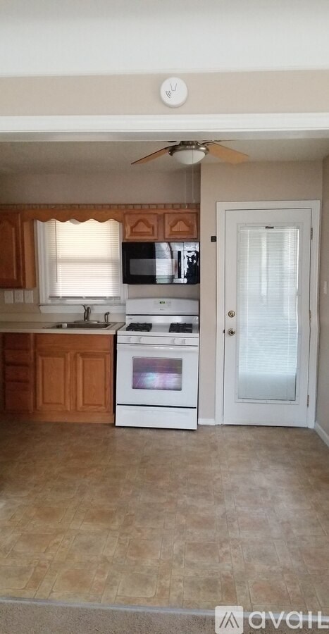 A kitchen with a white oven and wooden cabinets.