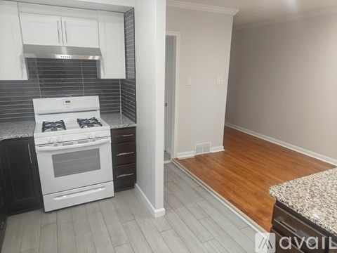 A kitchen with a white stove top oven and black cabinetry.