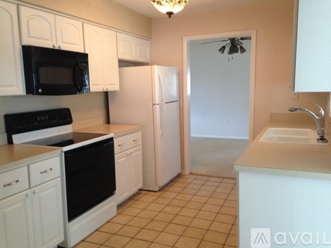 A kitchen with white cabinets and appliances.