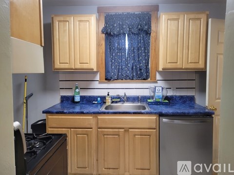 A kitchen with wooden cabinets and a blue granite countertop.