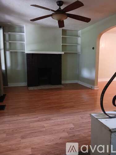 A room with a fireplace and a fan on the ceiling.