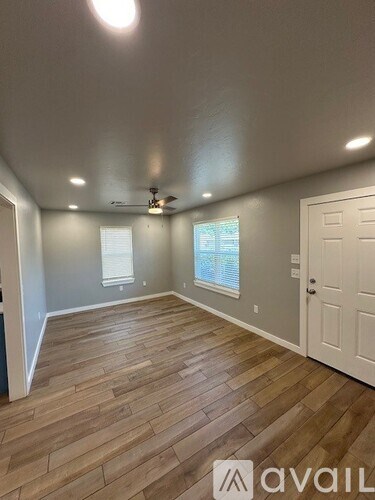 A room with wooden flooring and a ceiling fan.