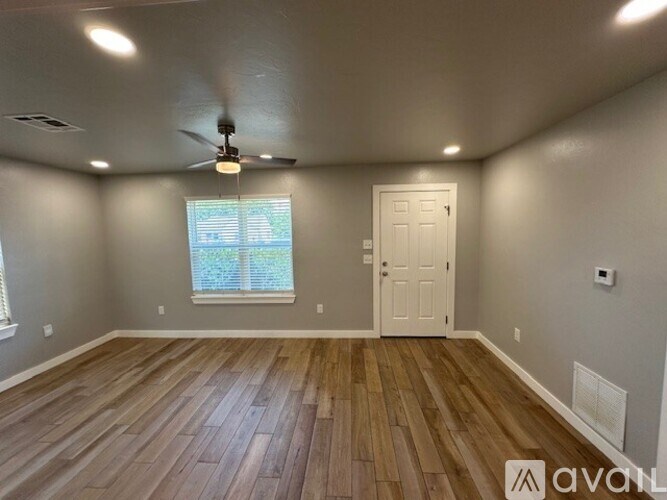 A room with wooden flooring and a ceiling fan.