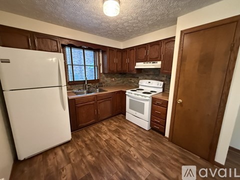 A kitchen with wooden cabinets and a white refrigerator.