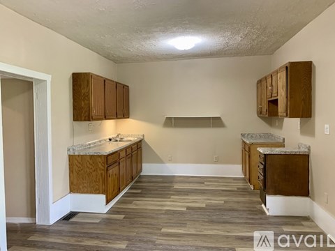 A kitchen with wooden cabinets and a marble countertop.