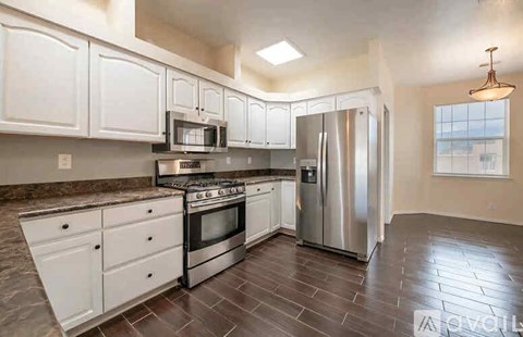 A kitchen with white cabinets and stainless steel appliances.