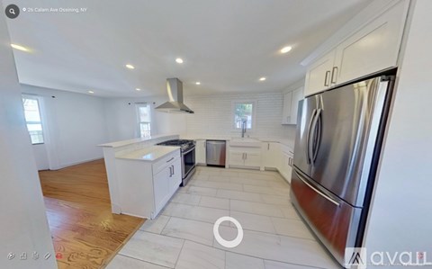 A modern kitchen with white cabinets and stainless steel appliances.