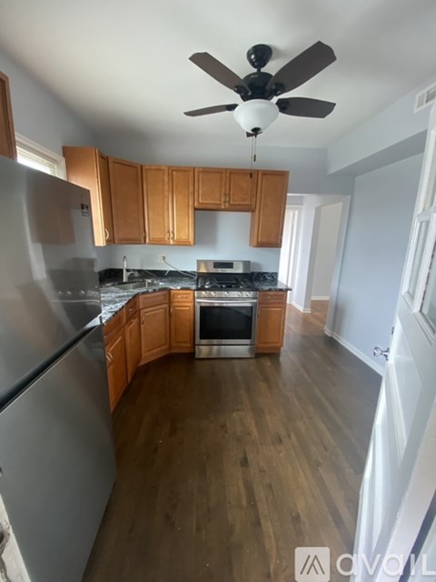 A kitchen with wooden cabinets and a stainless steel refrigerator.