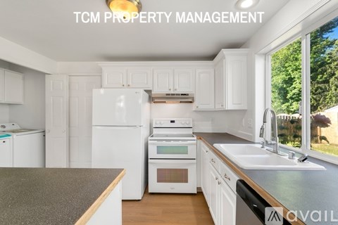 A kitchen with white appliances and cabinets is available for rent.