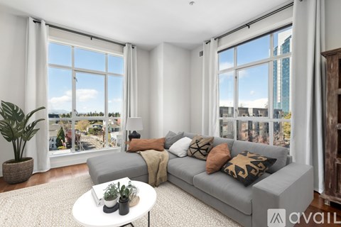 A living room with a grey couch and a white coffee table.