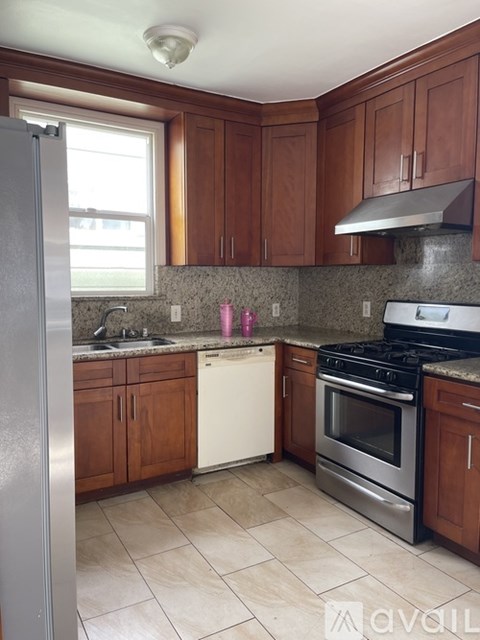 A kitchen with a refrigerator, oven, and sink.