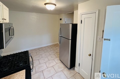 A kitchen with a black stove top and a black fridge.