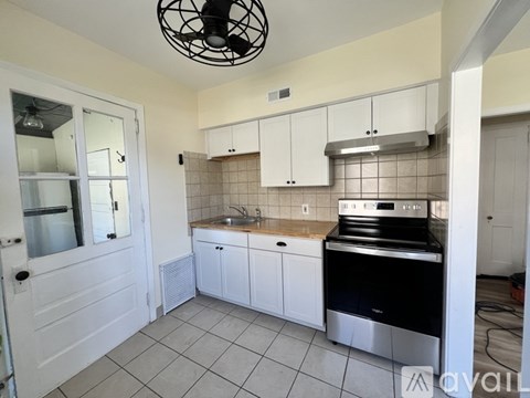 A kitchen with white cabinets and a black stove top oven.