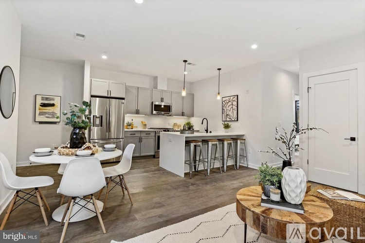 A modern kitchen with white chairs and a wooden coffee table.