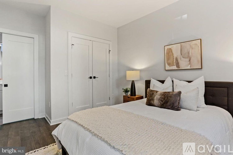 A bedroom with a large bed and a painting on the wall.