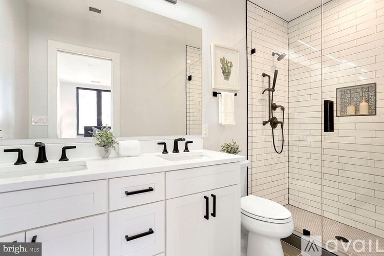 A white bathroom with a toilet, sink, and mirror.