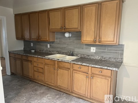 A kitchen with wooden cabinets and a granite countertop.